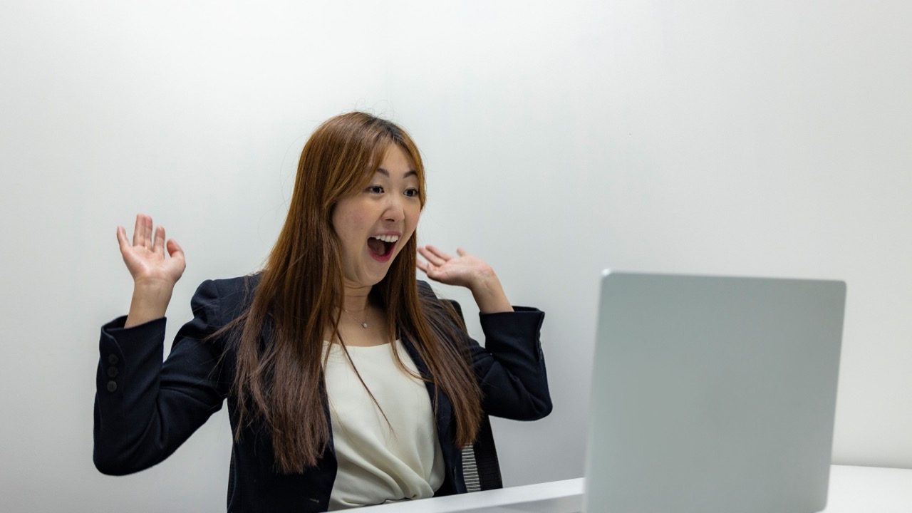 Team member celebrating while looking at a laptop screen